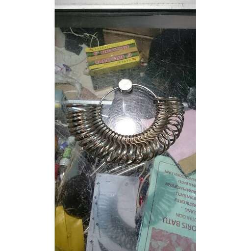 a metal sculpture hanging from a shelf in a shop.