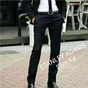 a man in a suit and tie standing on a sidewalk.