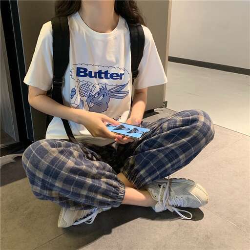 a girl sitting on the floor with a book in her lap.