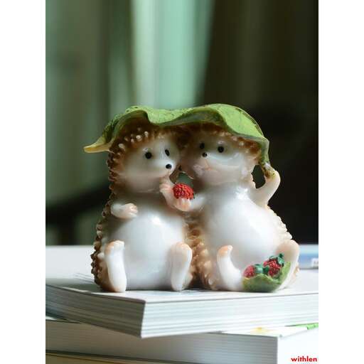 two cats sitting on top of a stack of books.