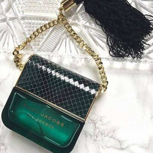 a green purse with a black and gold chain.