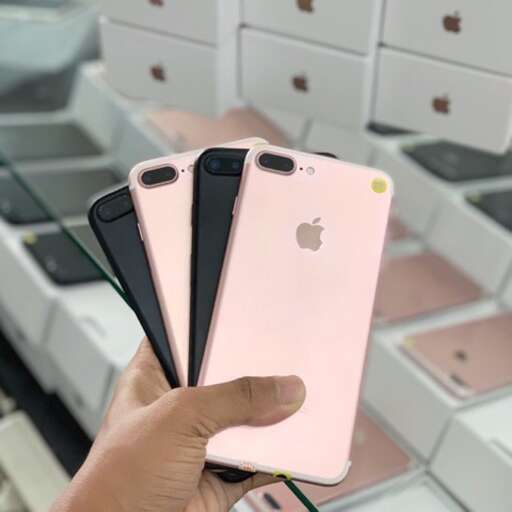 a person holding a pink iphone in a store.