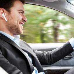 a man in a car talking on a cell phone