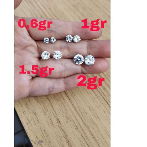 a woman's hand shows a pair of diamonds.