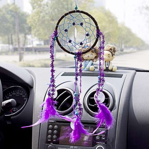 a clock hanging from the dashboard of a car.