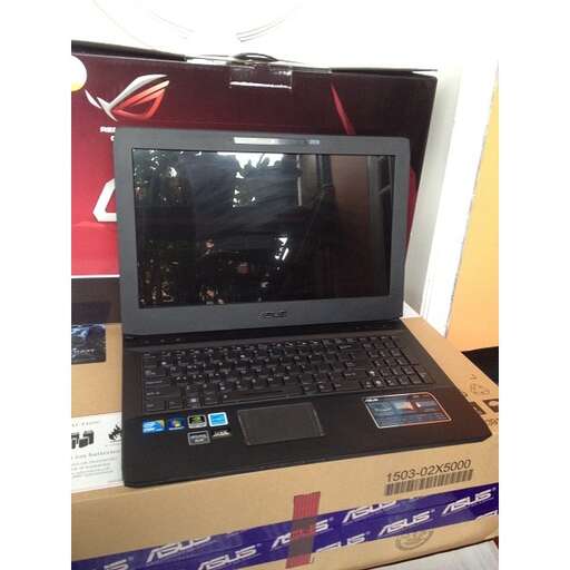 a laptop sitting on top of a cardboard box.