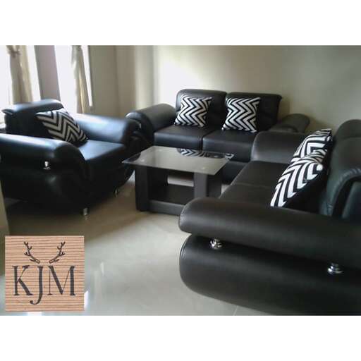 a black leather couch with a white and black accent chair.