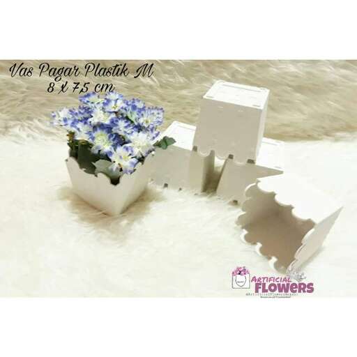 a flower pot with a small white flower in it.