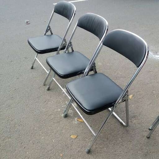 a pair of folding chairs sitting in a parking lot.