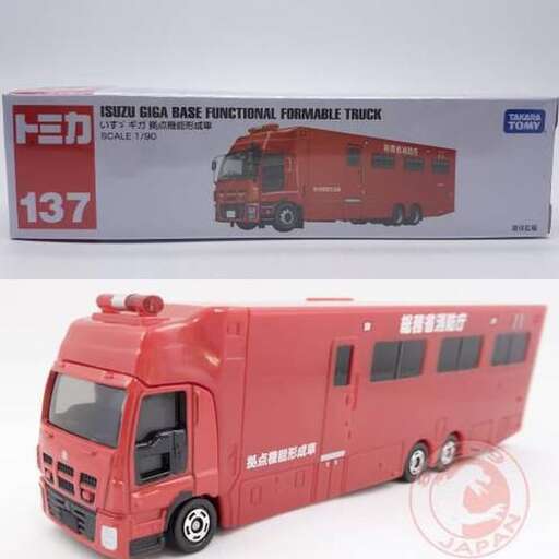 a red bus is next to a large box.