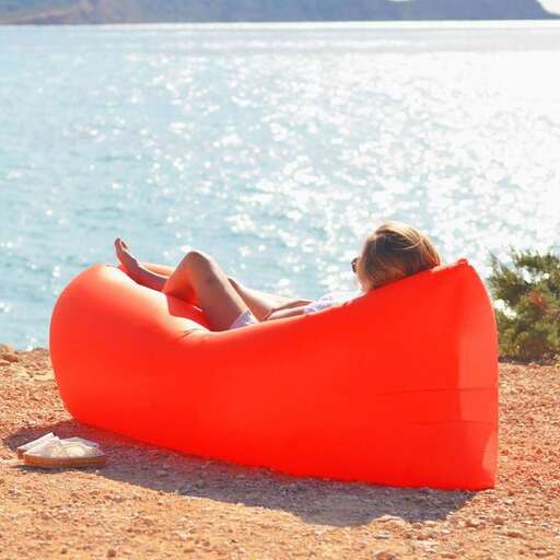a woman relaxing on an inflatable chair on the beach.