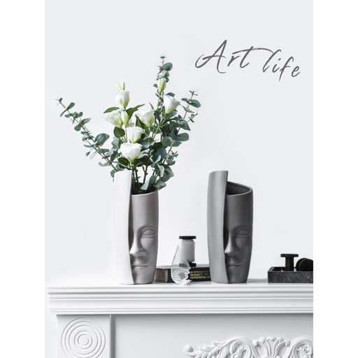 a white table with a vase of flowers and vases.