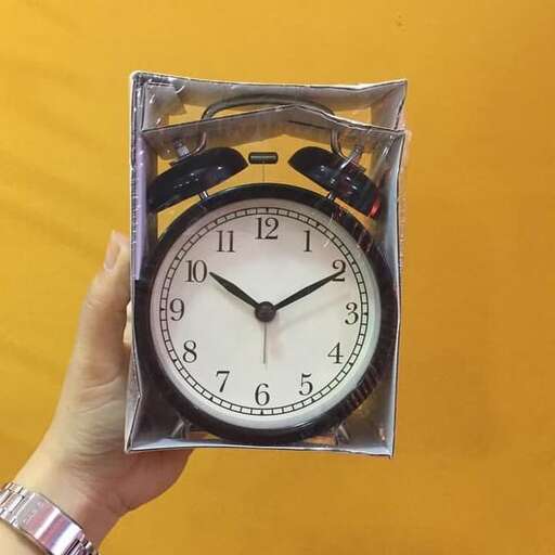 a clock in a plastic case with a black and white face.