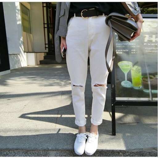 a pair of white jeans with a black jacket and white shoes.
