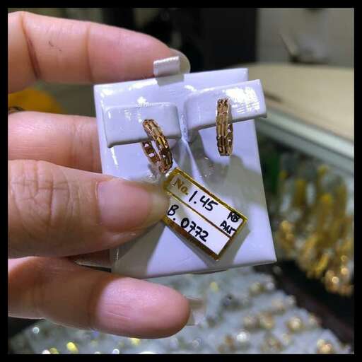 a hand holding a small box with a tag attached to it.