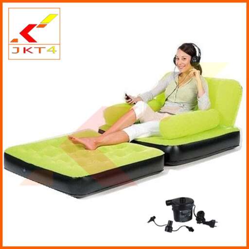 a woman sitting on a green couch with headphones.