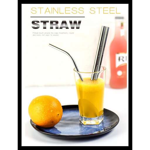 a glass of orange juice on a plate with a straw.