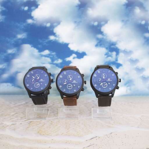 a watch on the beach with a blue sky and clouds
