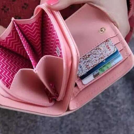 a pink purse with a wallet inside of it.