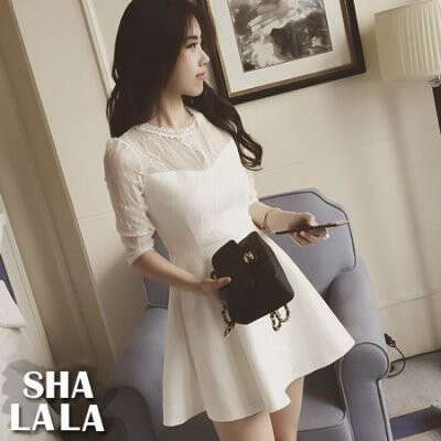 a woman in a white dress is holding a cell phone.