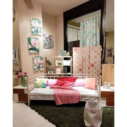 a bed with a pink and white bed in a room.