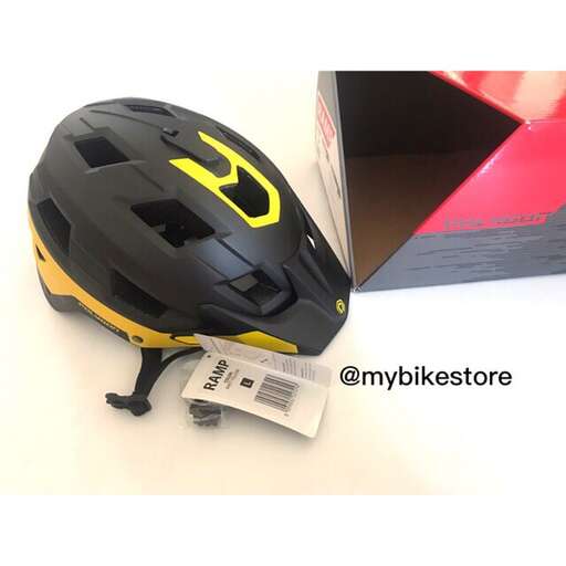 a black and yellow helmet sitting on top of a white surface.