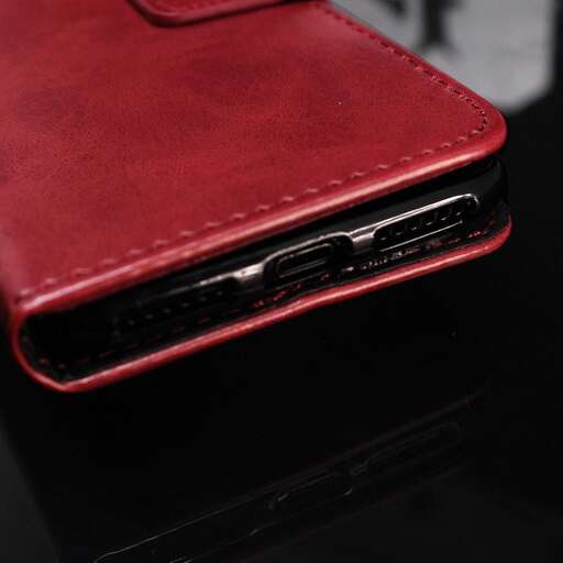 a red leather wallet with a black case on top of it.