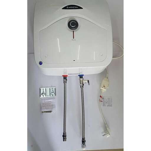a water heater mounted to a wall with a sink and a faucet.