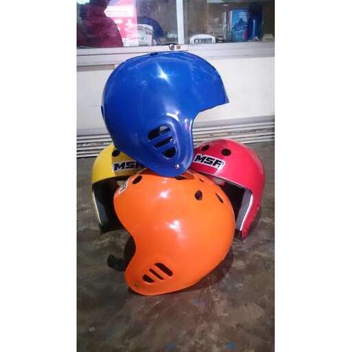 two helmets and helmets sitting on a floor.