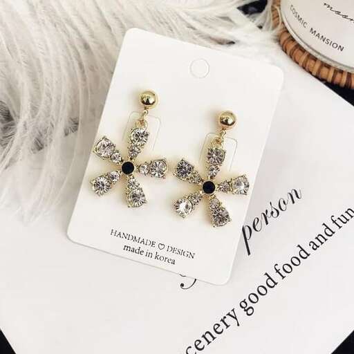 a pair of earrings with a black and white cross on top.