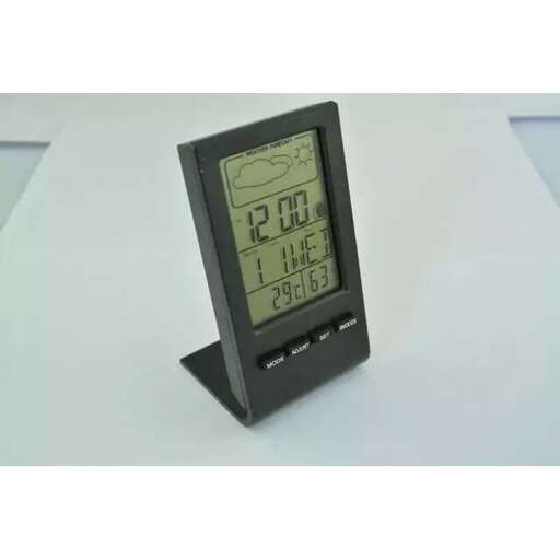 a black clock with a digital display on a table.