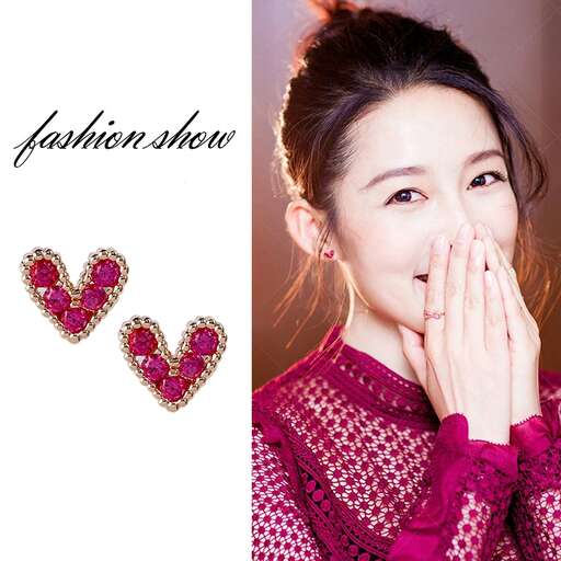 a woman in pink shirt and earrings