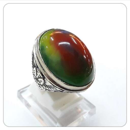 a ring made of sterling silver with a green stone in the middle.