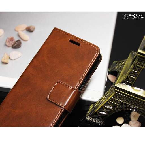 a cell phone sitting on top of a table next to a small set of shells.