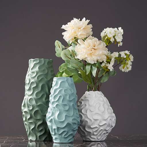 three vases with white flowers in them.