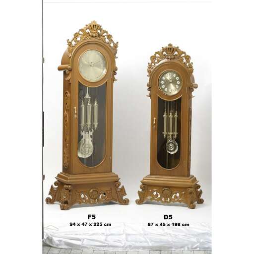 a large clock with a white face and a gold base.