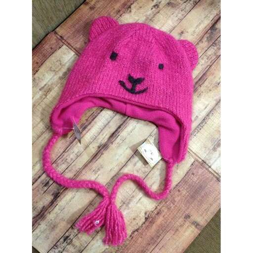 a pink knitted hat with a cute bear on it.