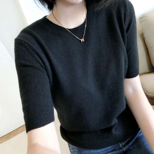 a woman wearing a black sweater and jeans.