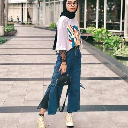 a graphic tee is worn with a pair of high - waisted jeans and a t - shirt.