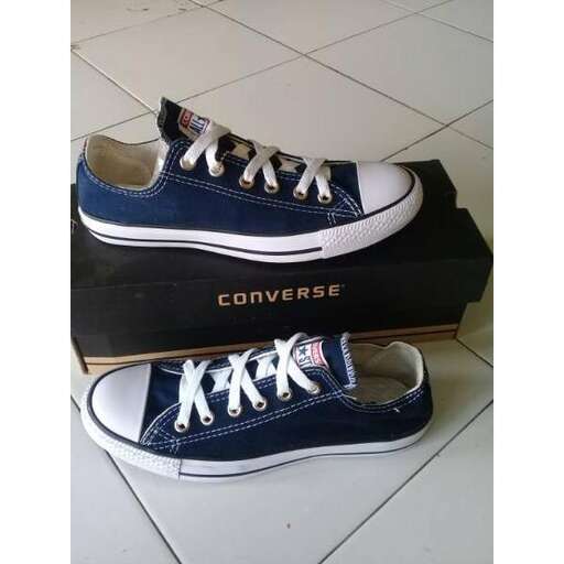 a pair of blue and white sneakers on a tile floor.