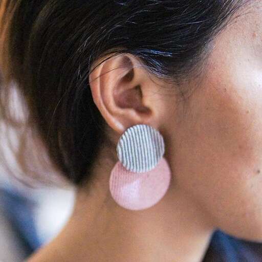 a pair of earrings with a pink and white geometric pattern.