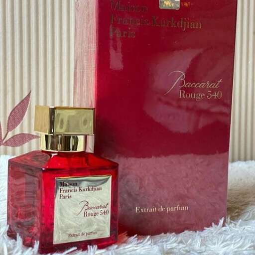 a bottle of perfume sitting on a blanket.