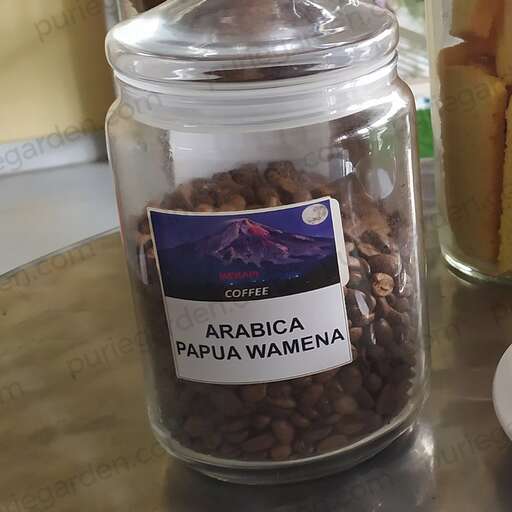 a jar of coffee beans and other food on a table.