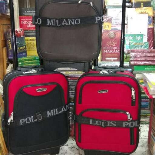 two suitcases sitting on the ground in front of a store.