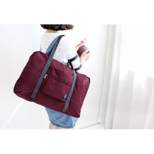 a woman carrying a large bag on her shoulder.