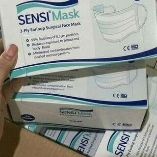 a person holding a box with a picture of a mask on it.