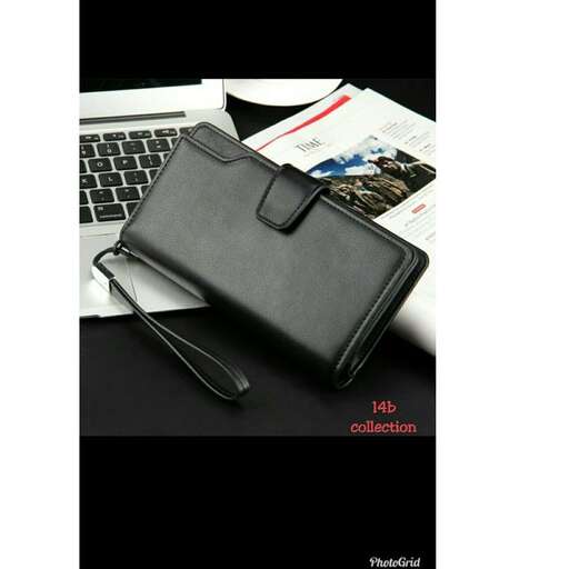 a black leather bag sitting on top of a desk.