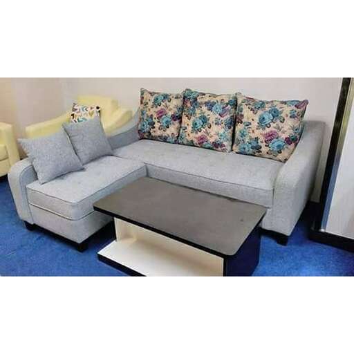 a living room with a couch, coffee table and pillows.