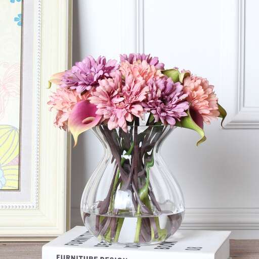 a vase filled with pink flowers sitting on top of a white box.