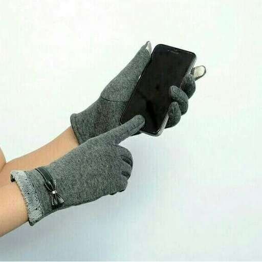 a person wearing a glove holding a cell phone.